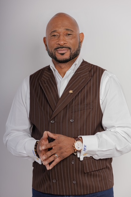 Portrait of Coach C in a brown pinstripe vest, founder of the Leadership & Success Institute